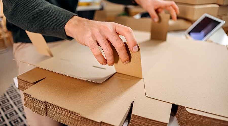 The-Product-Range-Man-folds-a-cardboard-box